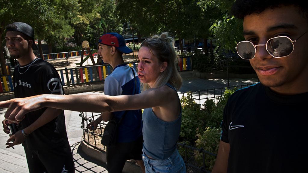 UN grupo de jóvenes, en un parque, junto a una referente de emancipación.